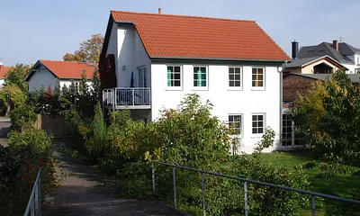 Ferienhaus von Süden, oben ist links und rechts jeweils ein Balkon