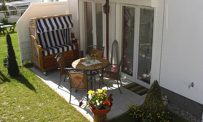 Der schöne Garten mit Terrasse. Hier befindet sich neben Gartenmöbeln ein Strandkorb zum relaxen  