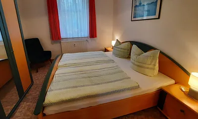 Schlafzimmer mit Doppelbett und Sessel
