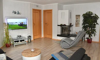 Wohnzimmer mit Schaukelstuhl zum wohlfühlen vor dem Kamin