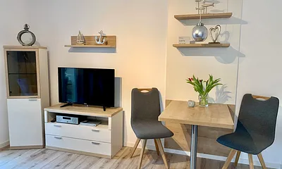 Freundlicher Wohnbereich mit LCD-TV, BluRay-Player und Radio