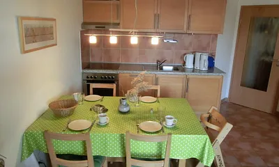 Eß- und Küchenbereich mit zusätzlich ausziehbarem Tisch und 5 Stühlen. Der auf dem Foto sichtbare Hochstuhl gehört zur Wohnung.