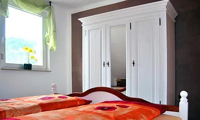 Schlafraum mit Doppelbett und großem Schrank