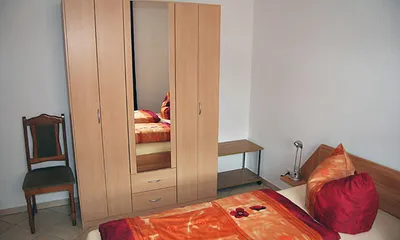 Schlafraum mit Doppelbett und großem Schrank