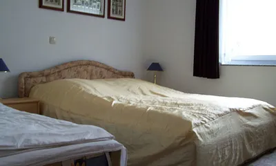 Schlafzimmer mit Doppelbett und separater Liege.