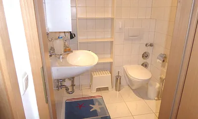 Badezimmer mit Dusche, Fußbodenheizung, großem Regal und Handtuchtrockner