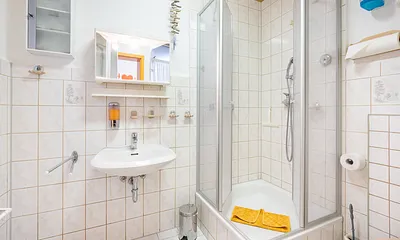 Ein  Duschbad mit WC und Tageslicht.  Einweg -Zahnbecher, Seife, Reinigungsmittel uvm.