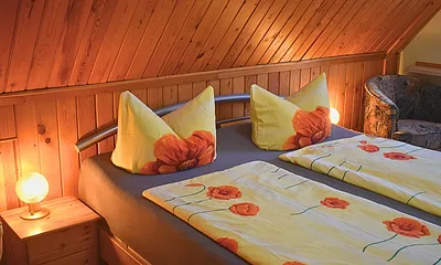 FeWo Knuth - Schlafzimmer mit Nachtschränken, Kommode, TV, Sessel