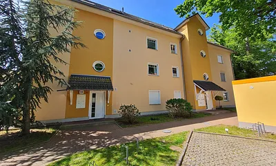 Vorderansicht Hauseingänge und Stellplätze