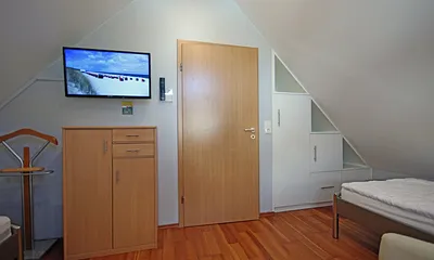Schlafzimmer im DG mit offenem Einbauschrank und Flach TV 32'' HD