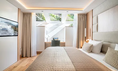 Schlafzimmer mit Smart TV, Schreibtisch und Bad en Suite