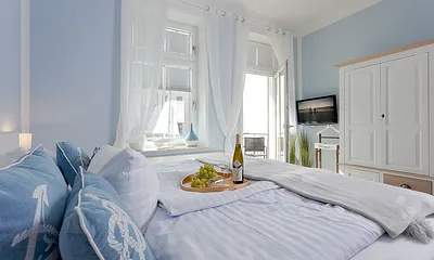 Schlafzimmer mit Doppelbett und Balkon