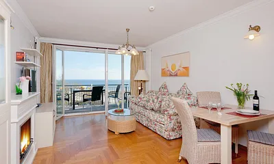 Ess- und Wohnbereich mit Bioethanolkamin und Balkon mit Meerblick