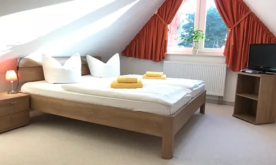großes , sehr schönes Schlafzimmer im Dachgeschoss mit einem großen Doppelbett und einem zusätzlichen Einzelbett , SAT-TV , erreichbar durch Treppe