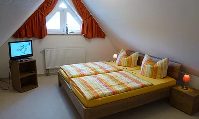 Schlafzimmer 2 mit Doppelbett und 1 Einzelbett und SAT-TV im Dachgeschoss