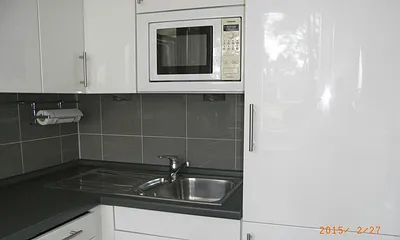 Küche mit Kühl-Gefrierkombination, Geschirrspüler und Mikrowelle