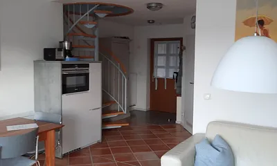 offener Wohnbereich mit Wendeltreppe in den oberen Schlafbereich