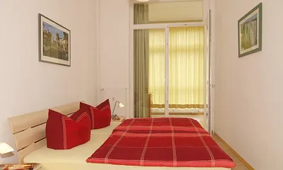 Schlafzimmer mit Doppelbett und ebenfalls mit Zugang zur sonnigen Loggia