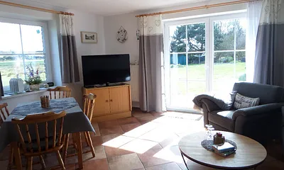 Essecke und Wohnstube mit großen, hellen Fenstern