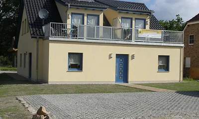 Hausansicht mit Stellplätzen