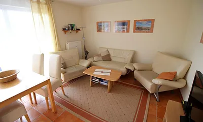 Wohnzimmer hat  bodentiefe Fenster und elektrische Aussenrollos. 