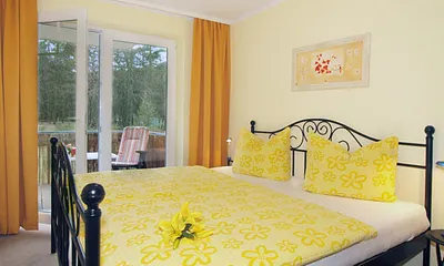Schlafzimmer mit Doppelbett und Zugang zum Balkon