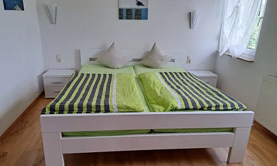 Schlafzimmer mit Kinderbett und Kabelfernseher.