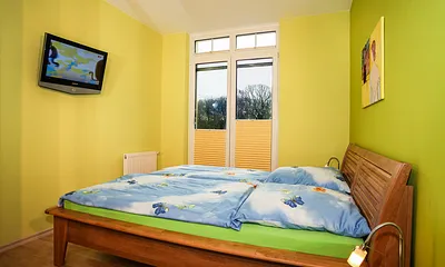 Schlafzimmer 1 mit Doppelbett und Fernseher