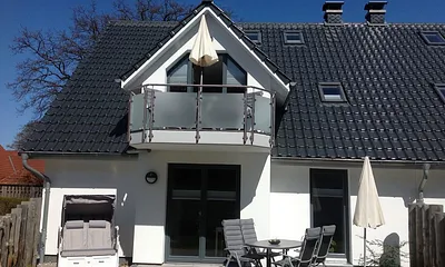 Die Süd-West Terrasse, ausgestattet mit Tisch/Relaxstühlen, Sonnenschirm und Strandkorb. 