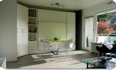 Wohnzimmer Schrankwand (2RaumWunder) Ausfahr-Doppelbett Komfortschaummatraze 1,60 x 2,00 m und integr. Eßtisch unterh. d. Betts autom. einklappend