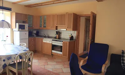 Küchenzeile mit Heißluftherd und Ceranfeld, Mikrowelle, Kühl-Gefrierkombination und Geschirrspüler. Außerdem Esstisch für 6 Personen mit Ostseeblick.