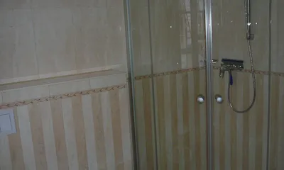 Bad im Schlafgeschoss mit Waschbecken, Ganzglasdusche, Toilette, Fußbodenheizung, Handtuchheizkörper und Außenfenster (nicht zu sehen) mit Fliegengitter