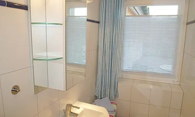 Modernes Bad mit flacher Dusche und WC