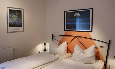 Schlafzimmer mit Doppelbett, Nachttischen, Leselampen und geräumigem Kleiderschrank