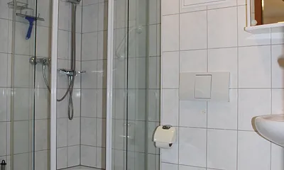 Badezimmer rundum gefließt mit beleuchtetem Spiegelschrank