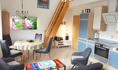 Essbereich mit großem 55'' Fernseher und Küche mit modernen Geräten