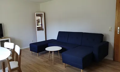 Das Wohnzimmer hat ein Fenster zur Südseite. Sie können mit Blick auf den Hof frühstücken oder auch auf dem Hof im Grünen sitzen.