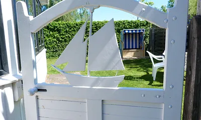 Eingang zum Ferienhaus und Garten mit gemütlicher Sitzgelegenheit