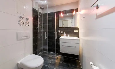 Das schicke Bad hat Echtglasdusche, WC und Waschbecken. 