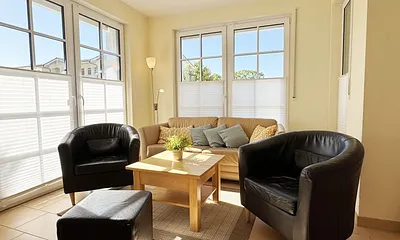 gemütliches Wohnzimmer mit Couch und Sessel