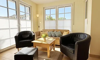 gemütliches Wohnzimmer mit Couch und Sessel