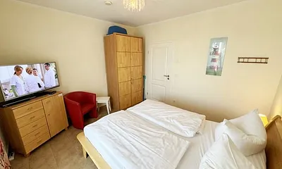 Schlafzimmer mit Doppelbett (2x 0,80 m x 2,00 m), Kleiderschrank, Wäschekommode, Sessel und LED-TV mit DVD