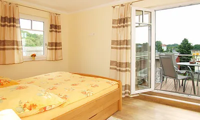 Schlafzimmer mit Doppelbett und Zugang zum Balkon