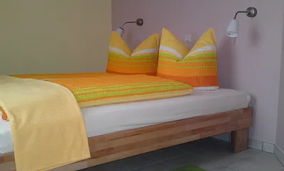 Im Schlafzimmer steht ein Doppelbett. Es ist Platz für ein Kinderbett.