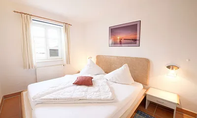 Das Schlafzimmer mit Doppelbett und im Sommerhalbjahr mit Insektenschutzfenstern.