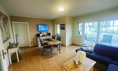 Das helle Wohnzimmer mit Blickrichtung Küche bietet Ihnen einen gemütlichen Aufenthalt.