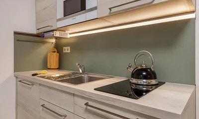 Die Küchenzeile ist ausgestattet mit Mikrowelle, Kühlschrank mit Eisfach, Induktionskochfeld mit passendem Kochgeschirr, Kaffeemaschine, Wasserkocher und Toaster.