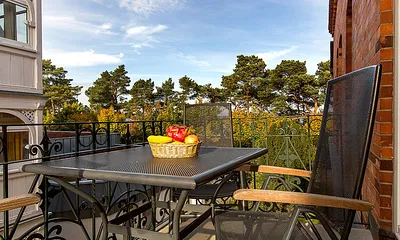 Die Ferienwohnung DolceVita hat einen schönen Balkon mit typischem schmiedeeisernen Geländer und wunderbarem Blick auf die Seebrücke und die Ostsee. Der Meerblick variiert mit Schnitt der Dünenbäume. 