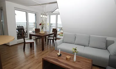 Wohnzimmer mit Balkon und Panoramablick auf die Hafenpromenade