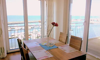 Essbereich mit Zugang zur Terrasse und Panoramablick auf den Wieker Hafen